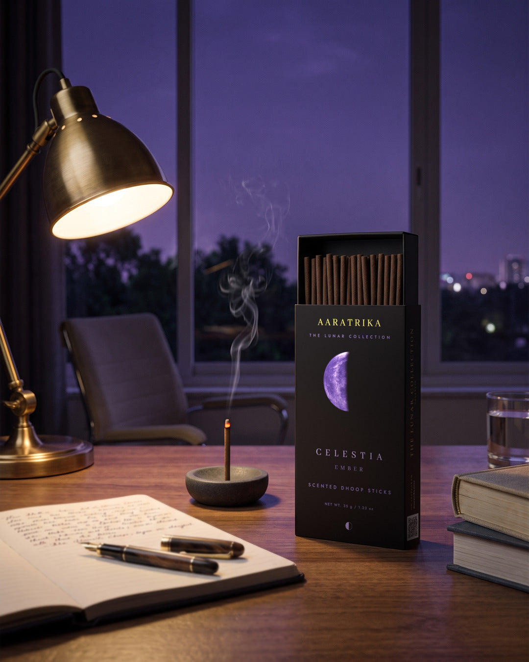 Celestia Ember compact dhoop sticks and packaging beside a notebook and brass reading lamp