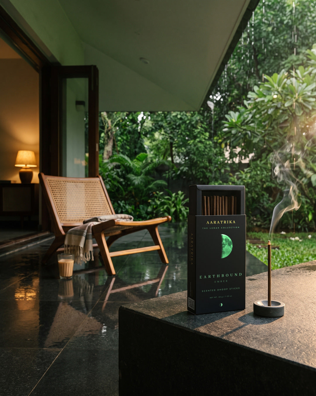 Earthbound Ember packaging and compact dhoop sticks by a rain-washed garden veranda