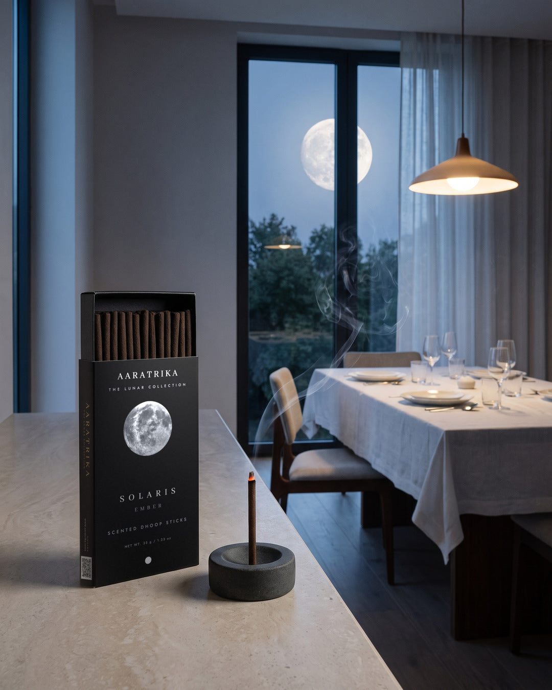 Solaris Ember packaging and compact dhoop sticks beside a dining table and moonlit window