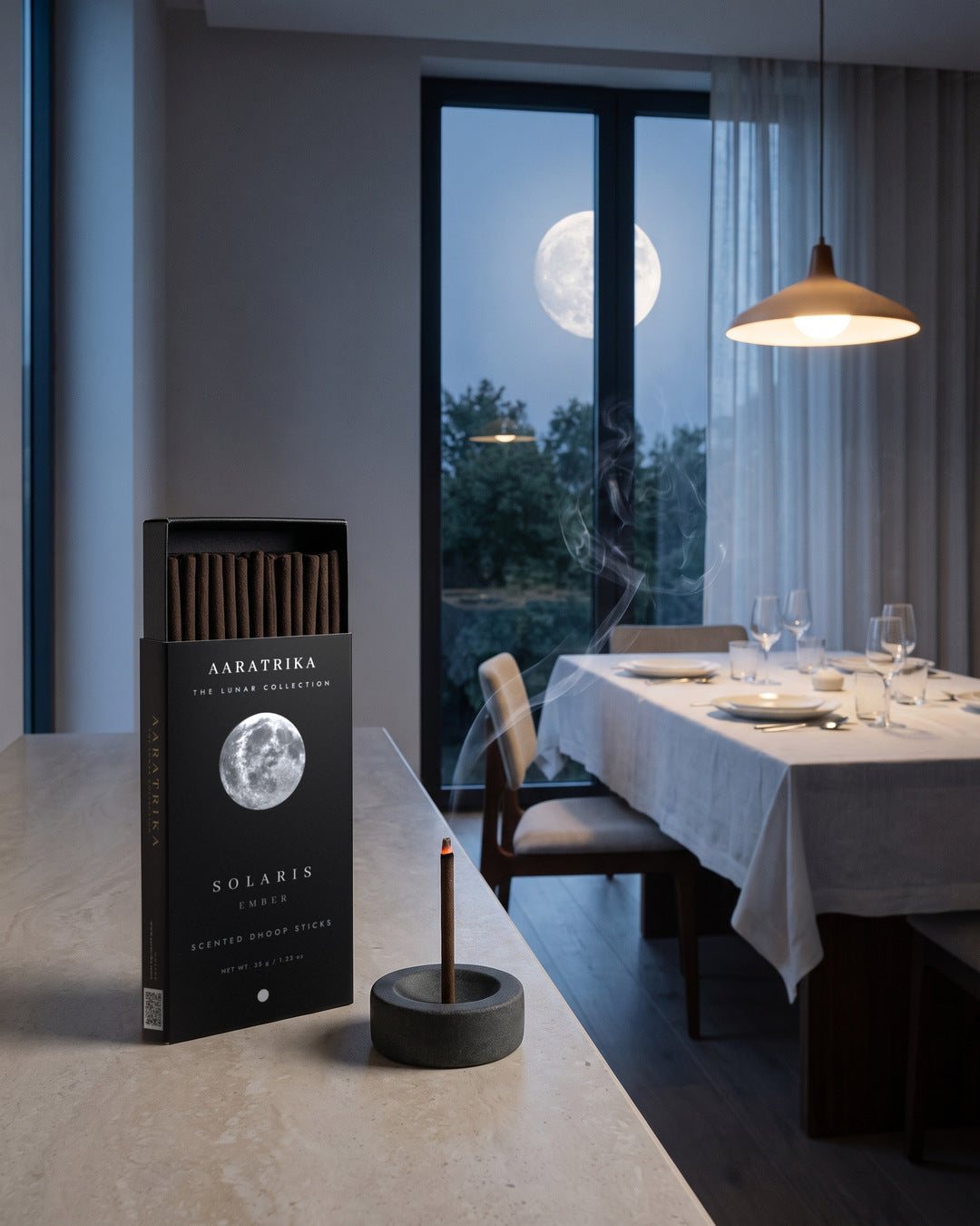 A dining table by a window with the full moon outside